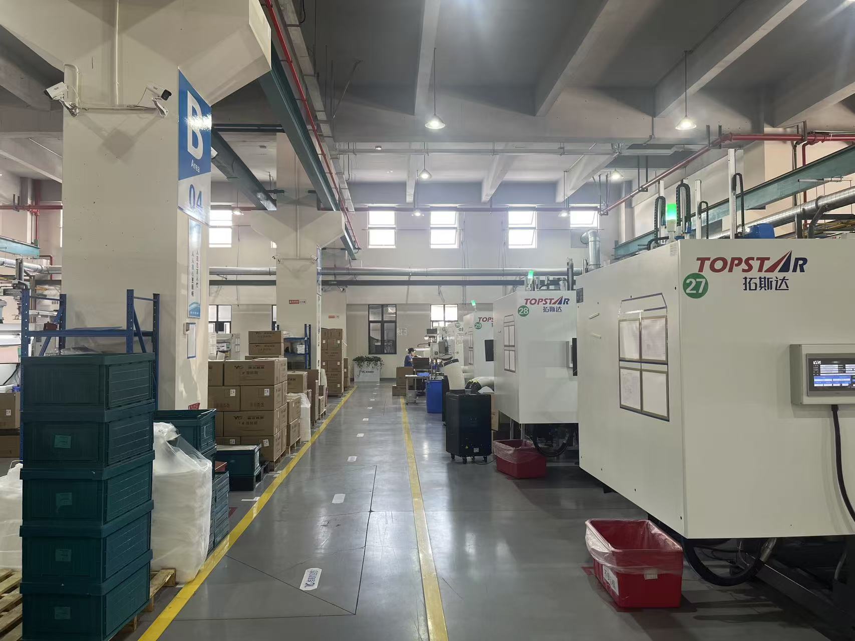 Tostar injection molding machines arranged along a marked production aisle